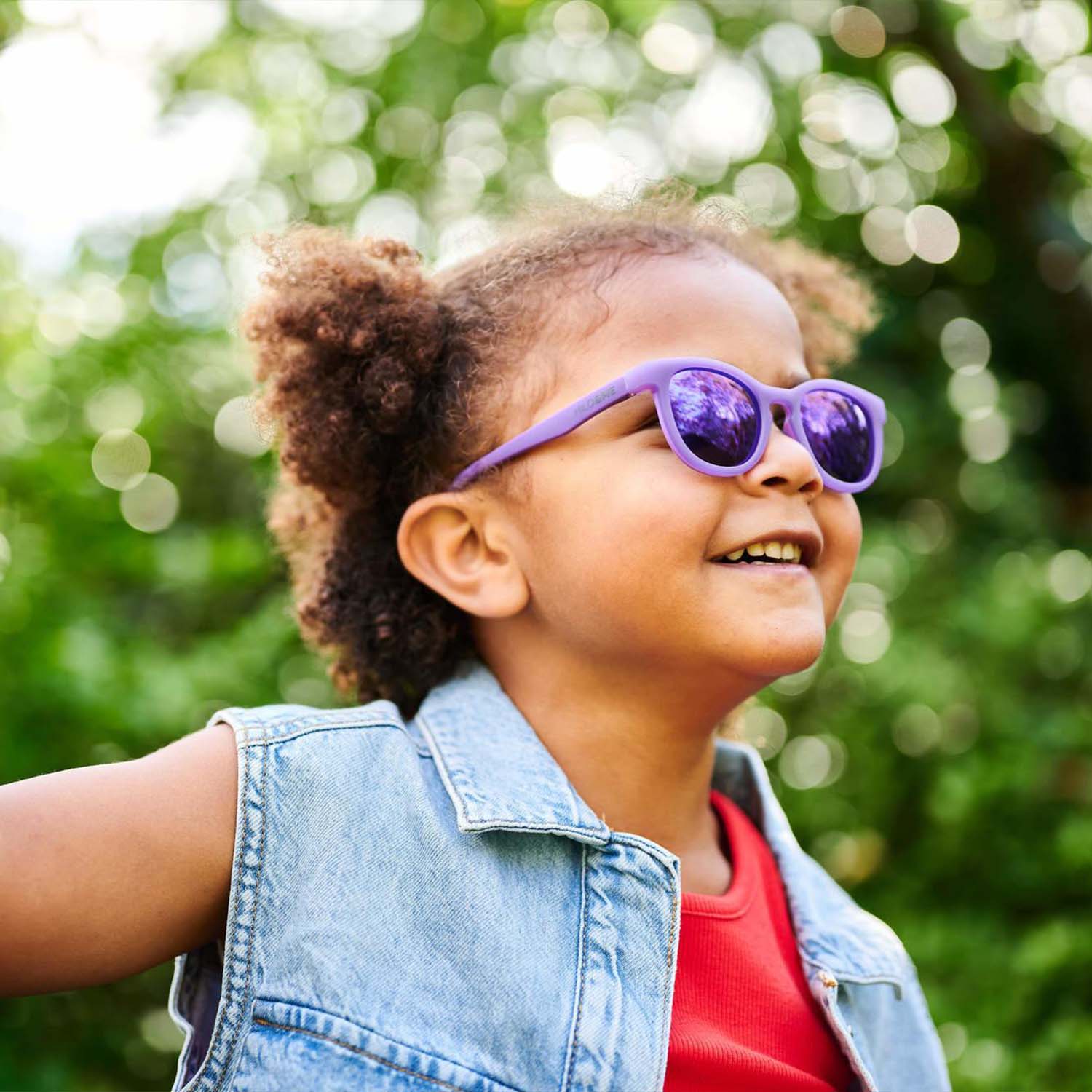 Milo & Me Kindersonnenbrille Noel Dunkellila Helllila Mädchen mit Braunen Locken und Jeansweste 3 - 5 Jährige 